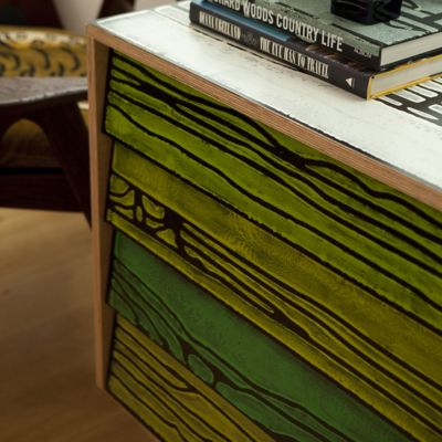Distressed chest of drawers used for display with books on top.