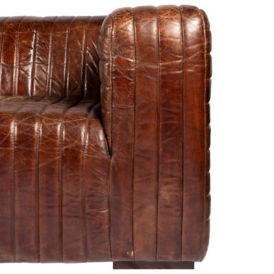 Close-up of brown leather tufted sofa section.